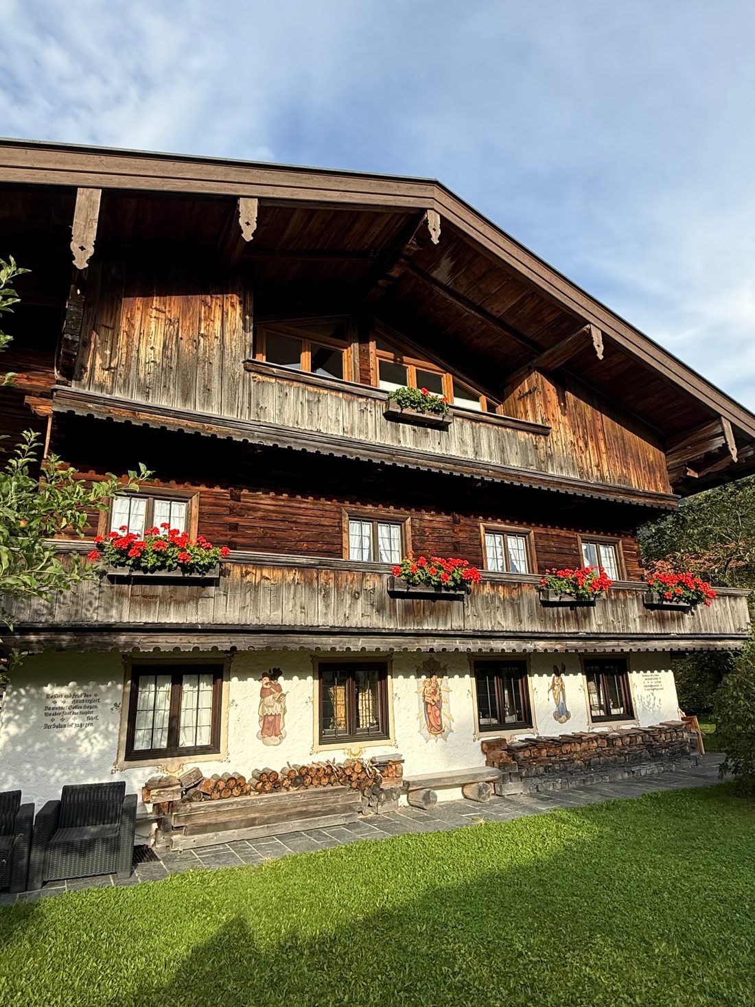 Die Fassade mit Laube und Geranien im Abendlicht